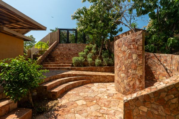 A pink Mexican limestone terrace sets the tone for the home's interior, which like the exterior embraces natural elements and local materials.