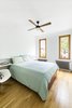 Modern home with Bedroom, Bookcase, Chair, Bed, Light Hardwood Floor, and Ceiling Lighting. The master bedroom. Photo 9 of Sunset Park Row House