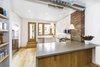 Modern home with Kitchen, Engineered Quartz Counter, White Cabinet, Light Hardwood Floor, Ceramic Tile Backsplashe, Ceiling Lighting, Refrigerator, Recessed Lighting, Range, Pendant Lighting, Microwave, and Dishwasher. The kitchen. Photo 6 of Sunset Park Row House