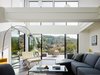 Modern home with Living Room, Sectional, Floor Lighting, Ceiling Lighting, Ottomans, Table Lighting, Bookcase, Coffee Tables, and Sofa. Natural light pours through the copious windows, filling the living areas with a sense of buoyancy, and allowing an unobstructed view of the vista beyond. Photo 2 of Orinda Connect 8+2