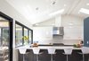 Modern home with Kitchen, Engineered Quartz Counter, Stone Slab Backsplashe, Vinyl Floor, Ceiling Lighting, White Cabinet, Pendant Lighting, Refrigerator, Cooktops, Dishwasher, Range, Undermount Sink, and Wine Cooler. Kitchen Photo of White House