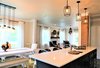 Modern home with Kitchen, Quartzite Counter, Medium Hardwood Floor, Dark Hardwood Floor, Engineered Quartz Counter, Colorful Cabinet, Wood Cabinet, Ceramic Tile Backsplashe, Mosaic Tile Backsplashe, Ceiling Lighting, Pendant Lighting, Accent Lighting, Recessed Lighting, and Drop In Sink. Kitchen with view of dining room and living room Photo 12 of A 1920's English Cottage