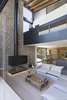 Modern home with Living Room, Sofa, and Light Hardwood Floor. The walls are covered in stone, to seem as they are coming through the earth, connected to the exposed wooden roof only through a series of triangular aluminum windows Photo 12 of The Wedge House