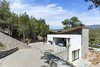 Modern home with Exterior, House Building Type, Shingles Roof Material, Stone Siding Material, Wood Siding Material, and Stucco Siding Material. The site’s steepness lead to an entrance and a car garage sitting on the first floor right above the living spaces Photo 5 of The Wedge House