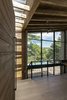 Modern home with Hallway and Light Hardwood Floor. The entrance opens up to the whole interior enclosure, immediately as someone enters, surprising the visitor to the house’s unpredictable nine-meter-height interior Photo 8 of The Wedge House