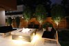 Modern home with Outdoor, Back Yard, Shrubs, Trees, Hardscapes, Grass, Raised Planters, Concrete Patio, Porch, Deck, Large Patio, Porch, Deck, Stone Patio, Porch, Deck, Horizontal Fences, Wall, Wood Fences, Wall, and Landscape Lighting. Back patio fire pit Photo 9 of Project 2575