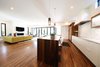 Modern home with Kitchen, Quartzite Counter, Wood Cabinet, Medium Hardwood Floor, Glass Tile Backsplashe, Pendant Lighting, Ceiling Lighting, Track Lighting, Recessed Lighting, Accent Lighting, Refrigerator, Wall Oven, Cooktops, Range Hood, Wine Cooler, Ice Maker, Dishwasher, Microwave, and Undermount Sink. Kitchen and Living Room Photo 10 of Project 2575