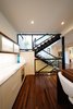 Modern home with Staircase, Glass Railing, Wood Tread, Wood Railing, and Metal Railing. Kitchen and staircase Photo 13 of Project 2575