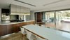 Modern home with Kitchen, Wood Cabinet, Travertine Floor, Quartzite Counter, Refrigerator, Ceiling Lighting, Cooktops, Wall Oven, and Drop In Sink. Kitchen Photo 4 of House at Los Cisnes