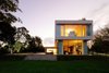 Modern home with Outdoor, Large Patio, Porch, Deck, Grass, Back Yard, Trees, and Wood Patio, Porch, Deck. Side view of the House at Los Cisnes at dawn. Concrete, Glass, Wood. Photo 13 of House at Los Cisnes