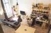 Modern home with Chair, Sofa, Pendant Lighting, Bookcase, Medium Hardwood Floor, Study Room Type, Shelves, Storage, Desk, Dining Room, Bar, and Table. The view from the top of Bence’s lofted bedroom reveals the open atmosphere in the living room, where open storage spaces are casually filled with personal effects Photo 4 of Micro live:work studio