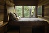Modern home with Bedroom, Dark Hardwood Floor, Bed, Pendant Lighting, Ceiling Lighting, Recessed Lighting, Shelves, and Night Stands. Guest bedroom at Residence 1414 by Miró Rivera Architects Photo 17 of Residence 1414