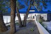 Modern home with Exterior, Gable RoofLine, Curved RoofLine, Concrete Siding Material, House Building Type, Metal Roof Material, and Glass Siding Material. The journey begins with a series of massive concrete walls that extend out into the landscape, creating a series of outdoor spaces and drawing visitors in. Photo of Vista Residence