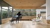 Modern home with Living Room, Recessed Lighting, End Tables, Shelves, Chair, Light Hardwood Floor, and Ceiling Lighting. A deep bench below the windows extends the length of the space, providing additional seating. In addition to large parties, the living room also plays to host music recitals. Acoustic wood ceiling panels enhance the sound quality and provide visual warmth. Built-in benches and steps allow guests to find a comfortable corner. Photo 16 of Vista Residence