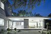Modern home with Exterior, Concrete Siding Material, Metal Roof Material, House Building Type, Curved RoofLine, Gable RoofLine, and Glass Siding Material. The master bedroom is enclosed on three sides, emphasizing the view outward, while the low-slung roof and deep eaves create a sense of horizontality. The bed, nightstands, and light shelf are made from white oak to match the floors; all were designed by the architects. Photo 5 of Vista Residence