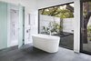Modern home with Bath Room, Recessed Lighting, Porcelain Tile Floor, Enclosed Shower, Freestanding Tub, Full Shower, Marble Wall, Ceiling Lighting, Mosaic Tile Wall, Stone Slab Wall, and Marble Floor. The theme of bringing the outdoors in continues in the master bathroom, which opens up to a private garden encircled by concrete walls beneath a canopy of oak trees; even the shower has direct access to the exterior. The palette of cool grays and white marble echoes the exterior finishes. Photo 6 of Vista Residence