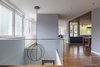 Modern home with Living Room, Medium Hardwood Floor, Ceiling Lighting, Recessed Lighting, and Pendant Lighting. The open floor plan highlights the dichotomy between the two halves of the site: ribbon windows screen the view of the street opposite picture windows that frame the treetops and lake. Photo 6 of Edgecliff Residence