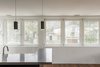 Modern home with Windows, Casement Window Type, Metal, and Wood. The main level houses the kitchen, dining, and living spaces, tied together by a continuous wooden wainscot whose series of half-round profiles echoes the design of the conduit screen outside. Photo 7 of Edgecliff Residence