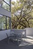 Modern home with Exterior, House Building Type, Stucco Siding Material, and Glass Siding Material. A sliding door opens onto a large outdoor deck that is connected to the yard via a staircase with a plate steel stringer. Photo 8 of Edgecliff Residence