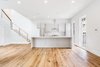 Modern home with Kitchen, Colorful Cabinet, Light Hardwood Floor, Granite Counter, Wood Cabinet, Subway Tile Backsplashe, Refrigerator, Microwave, Ceiling Lighting, Ice Maker, Dishwasher, Range Hood, Range, Wine Cooler, and Undermount Sink. Simple open floor plan concept. Photo 8 of Baker's Row