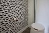 It's not completely removed from its element. Oak floors, bear wallpaper, and the toilet paper holder is a piece of madrone that fell in a storm this past winter. The ventilation tube, along with many other parts, were sourced from the local Rebuilding center at a hefty discount. Photo 3 of The Cube modern home