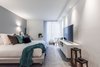 Modern home with Bedroom, Chair, Storage, Bed, Ceiling Lighting, Recessed Lighting, Pendant Lighting, Concrete Floor, and Rug Floor. Nathalie milazzo mixed side century modern with modern furniture Photo 5 of Riviera Miami Beach