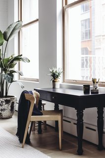 A quiet workspace with black mango wood gear table by Club CU sits in the living room, overlooking the city. 