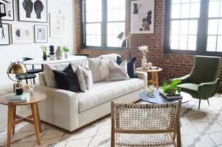 The living room exudes cozy, yet polished, vibes. A Kyle Schuneman for Apt2B Harper Sofa with pecan base sits across from a Safavieh Roe retro coffee table. The Verona Home Promesa Danish wood accent table is topped with a Pacific Coast Lighting Metal Table Lamp in antique brass.