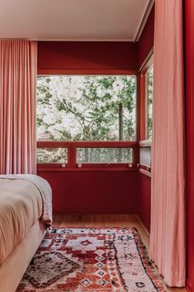 A Rejuvenation rug, drapes from The Shade Store, and bedding from Parachute all echo the rust and pink palette. 