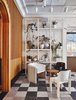 Modern home with Living Room, Ceiling Lighting, Chair, Concrete Floor, Shelves, Terrazzo Floor, End Tables, and Track Lighting. One of the sitting areas in the lobby immersed in plants and natural light. Photo 3 of Sister City