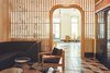 Modern home with Living Room, Sofa, Chair, Ceiling Lighting, Sectional, Concrete Floor, Pendant Lighting, Terrazzo Floor, and End Tables. Peering into the lobby through a latticed wall with arched door. It's these details that add a whimsical element to the hotel. Photo 4 of Sister City