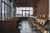 Modern home with Dining Room, Ceiling Lighting, Bench, Table, Bar, Lamps, Chair, Stools, Concrete Floor, Wall Lighting, Accent Lighting, Track Lighting, and Pendant Lighting. Last Night is permeated with wood slats, creating a warm space to sip and mingle. Photo 8 of Sister City