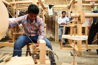 Artisans weave in a workshop.