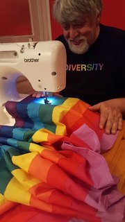 Baker sewing the nine-color diversity flag.