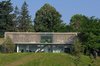 Modern home with Concrete Siding Material, Metal Siding Material, Wood Siding Material, House Building Type, Outdoor, Field, Shrubs, Back Yard, Slope, Woodland, Grass, and Trees. The house nestled in the forest Photo of Biscuit House