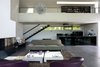 Modern home with Sofa, Recliner, Chair, Coffee Tables, Ceiling Lighting, Concrete Floor, Standard Layout Fireplace, Staircase, Metal Tread, and Metal Railing. the livingroom Photo 4 of Chipster Blister House