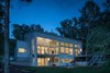 Modern home with Outdoor, Back Yard, Trees, Retaining Fences, Wall, Stone Patio, Porch, Deck, Metal Patio, Porch, Deck, Landscape Lighting, Stone Fences, Wall, Wood Patio, Porch, Deck, Decking Patio, Porch, Deck, and Walkways. Evening view from lake Photo 3 of Khabensky Residence