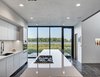 Modern home with Quartzite Counter, White Cabinet, Dark Hardwood Floor, Ceramic Tile Backsplashe, Wood Cabinet, Recessed Lighting, Wall Oven, Refrigerator, Cooktops, Wine Cooler, Dishwasher, Microwave, Undermount Sink, and Kitchen. View to the kitchen island overlooking the Missouri River. (2017) Photo 6 of 530 house