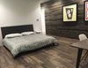 Modern home with Bedroom, Bed, Night Stands, Recessed Lighting, and Dark Hardwood Floor. View showing the guest bedroom with the formerly-exterior cedar-sheathed wall in the background. (2017) Photo 20 of 530 house