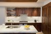 Modern home with Kitchen, Marble Counter, Wood Cabinet, Stone Slab Backsplashe, Ceiling Lighting, Pendant Lighting, Light Hardwood Floor, Accent Lighting, Recessed Lighting, Refrigerator, Wall Oven, Cooktops, Range, Range Hood, Wine Cooler, Ice Maker, Dishwasher, Microwave, and Undermount Sink. Walnut and book-matched Calcutta kitchen Photo 6 of Pierhouse At Brooklyn Bridge Park Condo