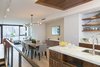 Modern home with Kitchen, Marble Counter, Wood Cabinet, Light Hardwood Floor, Stone Slab Backsplashe, Ceiling Lighting, Pendant Lighting, Cooktops, Recessed Lighting, Accent Lighting, Refrigerator, Wall Oven, Range, Range Hood, Wine Cooler, Dishwasher, Microwave, and Undermount Sink. Kitchen to Dining Room Photo 5 of Pierhouse At Brooklyn Bridge Park Condo