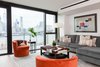 Modern home with Living Room, Chair, Sofa, Sectional, Coffee Tables, End Tables, Floor Lighting, Ottomans, Gas Burning Fireplace, Ceiling Lighting, Recessed Lighting, and Light Hardwood Floor. Living Room Photo 4 of Pierhouse At Brooklyn Bridge Park Condo