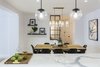 Modern home with Dining Room, Ceiling Lighting, Shelves, Bar, Light Hardwood Floor, Table, Pendant Lighting, Wall Lighting, Chair, Stools, Medium Hardwood Floor, and Lamps. View of Entry from Kitchen showcasing the custom Foyer window glazing. Photo of Upper East Side Oasis
