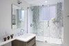 Modern home with Bath Room, Enclosed Shower, Undermount Sink, Marble Floor, Quartzite Counter, Soaking Tub, Engineered Quartz Counter, Full Shower, Ceiling Lighting, Porcelain Tile Wall, Wall Lighting, Whirlpool Tub, One Piece Toilet, and Accent Lighting. Master Bathroom Photo 8 of Upper East Side Oasis