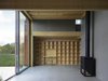 Living room's north side with a built-in bookcase and glass opening to the wide open landscape. Floors of glossy concrete, plywood walls and gray wood fiber boards (type Valchromat), floor tiles and solid plywood furnishings. Photo 11 of Späckhuggaren modern home