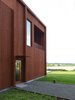 Modern home with Exterior, House Building Type, and Wood Siding Material. Entrance hall overlooking the countryside in the south. The façade is treated with a lighter version of Falu red color. Plate details around windows, rails and screen ceilings are treated with the same color scale. Photo 7 of Späckhuggaren