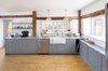 Modern home with Kitchen, Ceiling Lighting, Stone Counter, Colorful Cabinet, Light Hardwood Floor, Drop In Sink, Subway Tile Backsplashe, Granite Counter, and Dishwasher. Kitchen with window to the sunporch Photo 6 of Vermont Barn to High Performance Home