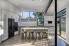 Modern home with Kitchen, White Cabinet, Porcelain Tile Floor, Ceiling Lighting, Recessed Lighting, Pendant Lighting, Refrigerator, Wall Oven, Cooktops, Microwave, Dishwasher, and Undermount Sink. The kitchen is positioned in the center of the house and serves as the primary space of domestic convergence. Photo 6 of 328 Koser