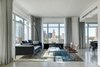 Modern home with Living Room, Lamps, Storage, Console Tables, Sofa, Chair, Coffee Tables, and Concrete Floor. The primary living space is located at the corner of the condo offering views to downtown. Photo of Whiteline Residence