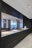 Modern home with Kitchen, Wood Cabinet, Concrete Floor, Cooktops, Ceiling Lighting, Recessed Lighting, and Engineered Quartz Counter. Dark-stained white oak and a marble counter top frames the kitchen. Photo 7 of Whiteline Residence